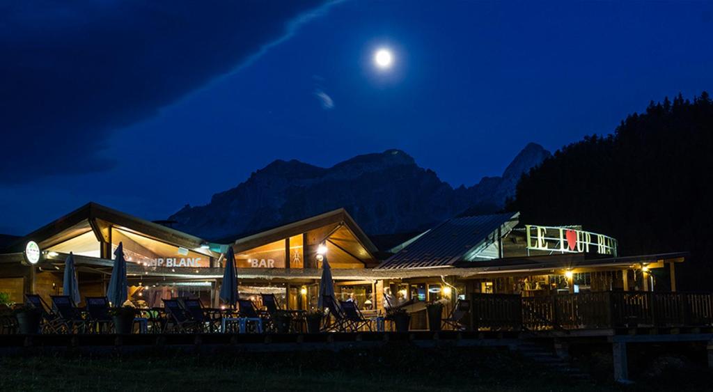 a restaurant at night with the moon in the sky at Le Loup Blanc in Pra-Loup