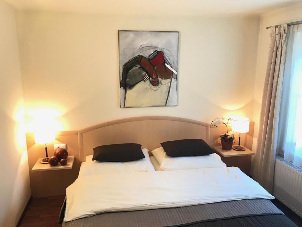 アルテンマルクト・イム・ポンガウにあるAppartements Unterdorferのベッドルーム1室(ベッド1台付)が備わります。壁には絵画が飾られています。