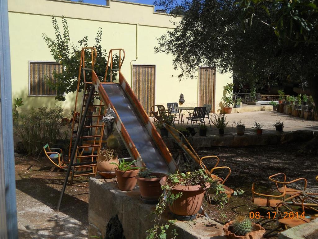 un jardin avec toboggan et plantes en pot dans l'établissement Villa Conte in Salento, à Francavilla Fontana