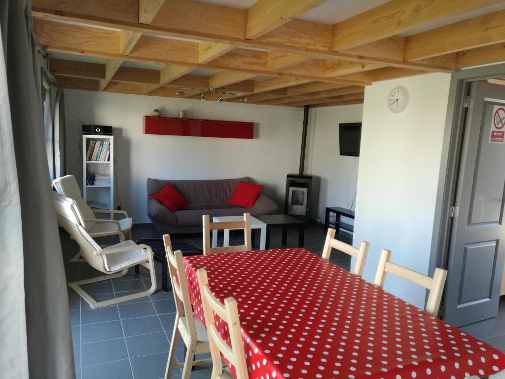 uma sala de estar com uma mesa e cadeiras vermelhas e um sofá em Wenduine zeehuisje 16 em Wenduine