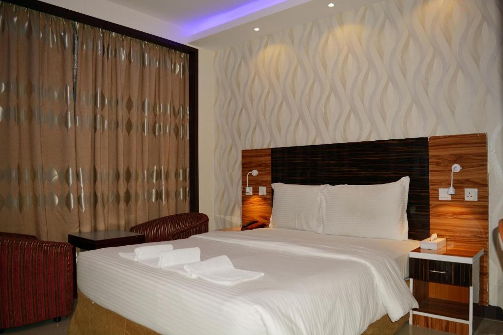 a bedroom with a large bed with white sheets at Zagy Hotel in Dubai