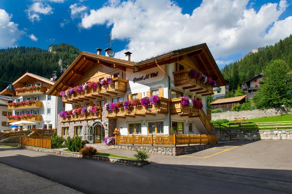 ein großes Gebäude mit Blumen auf den Balkonen in der Unterkunft Hotel Al Viel B&B in Canazei