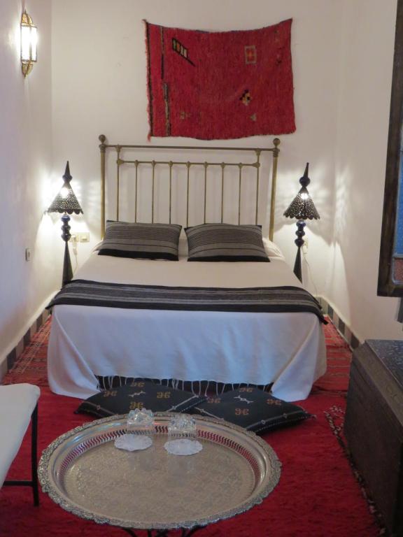 a bedroom with a bed with a table and two lamps at Riad Arous Chamel in Tangier