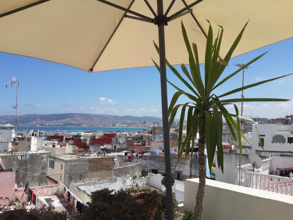 a view of a city from a balcony with an umbrella at Riad Arous Chamel in Tangier