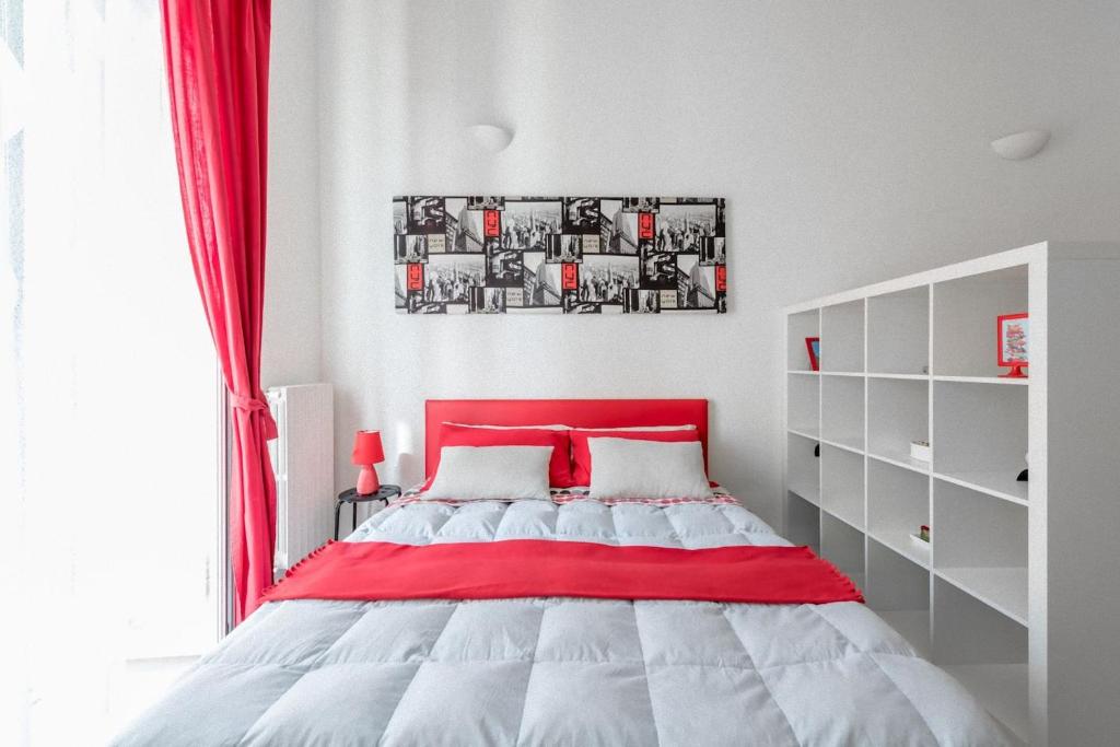 a red and white bed in a white bedroom at A due passi dal centro - Bari Policlinico in Bari