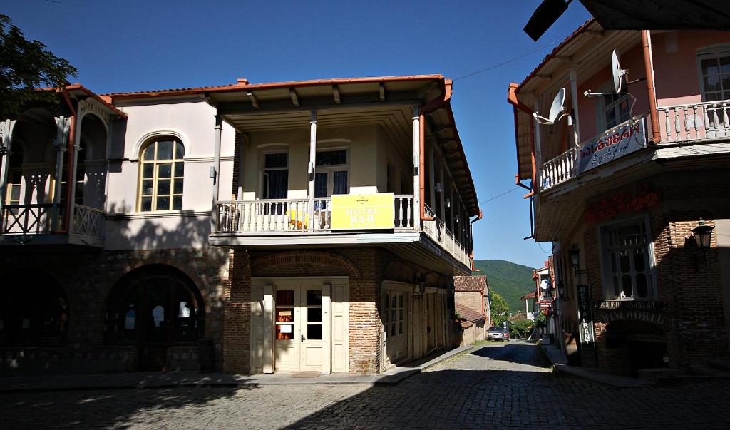 un ancien bâtiment avec un balcon dans une rue dans l'établissement Nana's Guest House, à Sighnaghi
