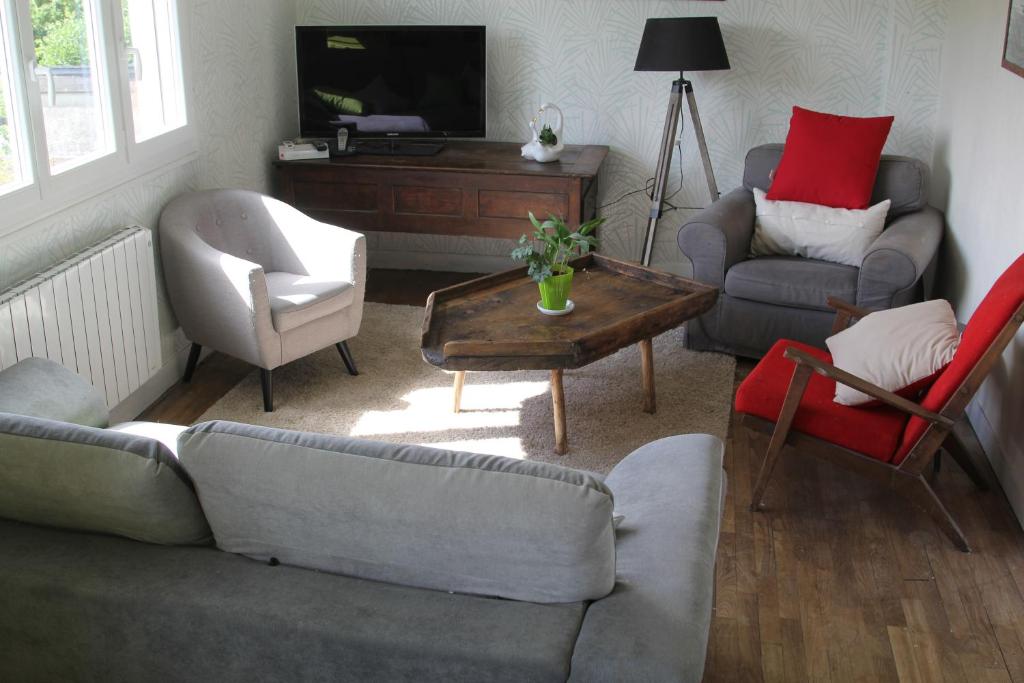 a living room with a couch and chairs and a tv at Appartement lumineux et Agréable 6 Personnes in Saint Malo