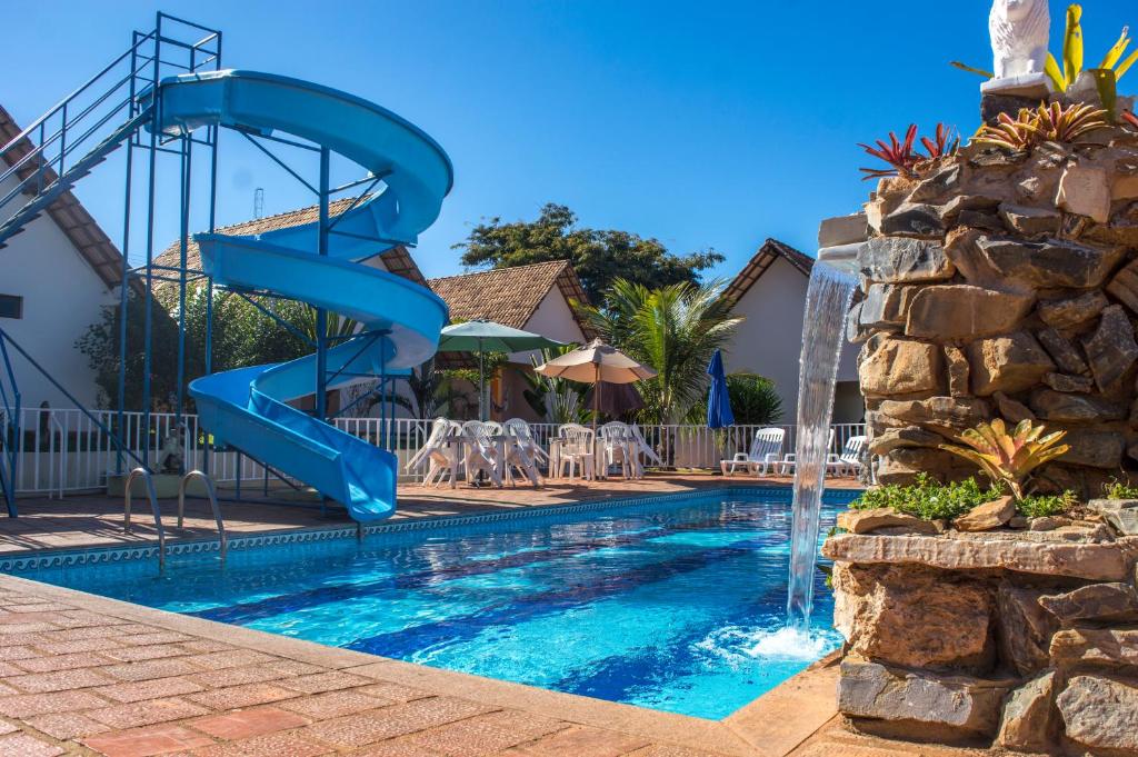 a blue water slide next to a pool at Pousada Sol Nascente in Paraopeba