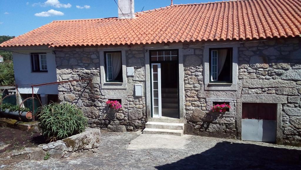 ein Steinhaus mit einem orangefarbenen Kacheldach in der Unterkunft Casa do Carqueijo in Vila Praia de Âncora