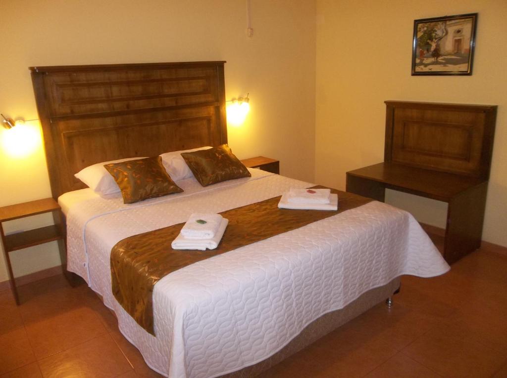 a bedroom with a large bed with two towels on it at Posada Maria in Trinidad