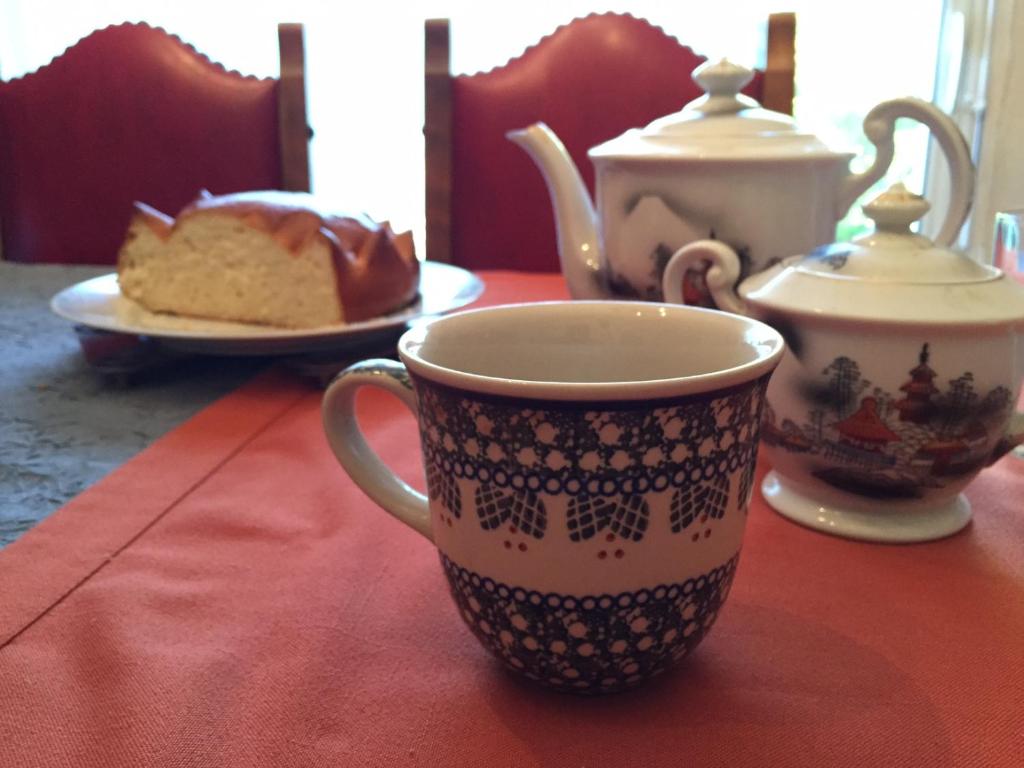 - une table avec une tasse de thé et une assiette de gâteau dans l'établissement Hon-ty, à Groix