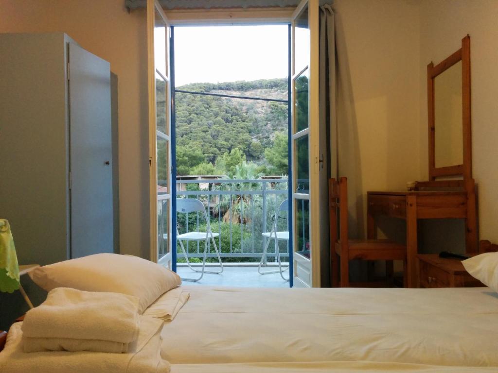a bedroom with a bed and a sliding glass door at Panos Studios in Poros