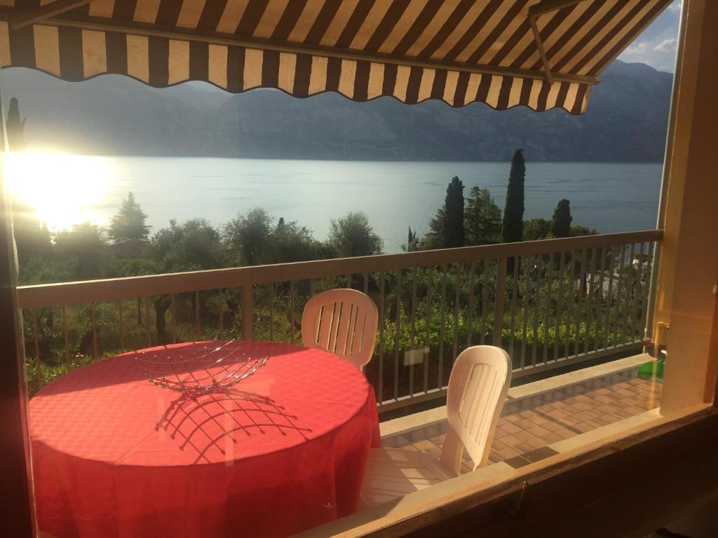 a table and chairs on a balcony with a view of the water at Casa Angelo in Malcesine