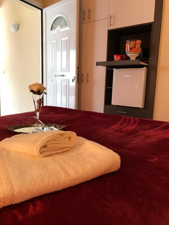 a towel sitting on top of a red bed at Corali in Menídion
