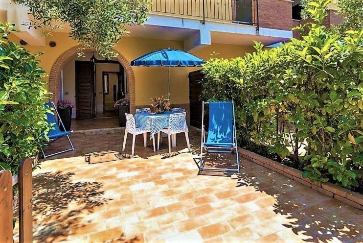 a patio with a table and a blue umbrella at Residence Blue Pearl in Marina di Camerota