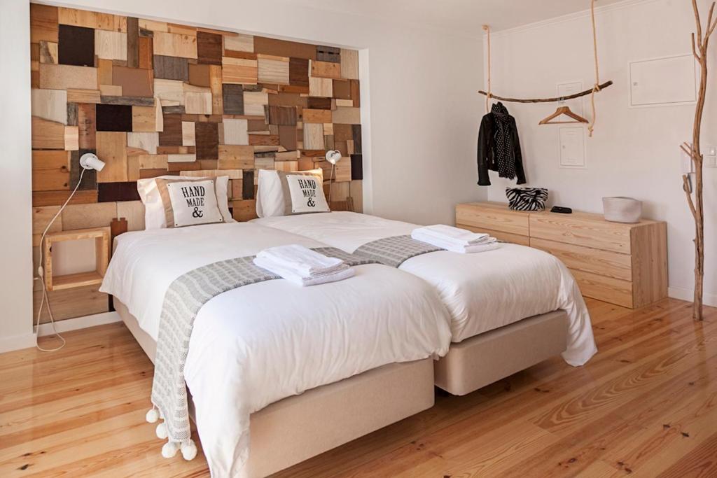 リスボンにあるBairro Alto Studio Apartments - by LU Holidaysの木製の壁のベッドルーム1室(ベッド2台付)