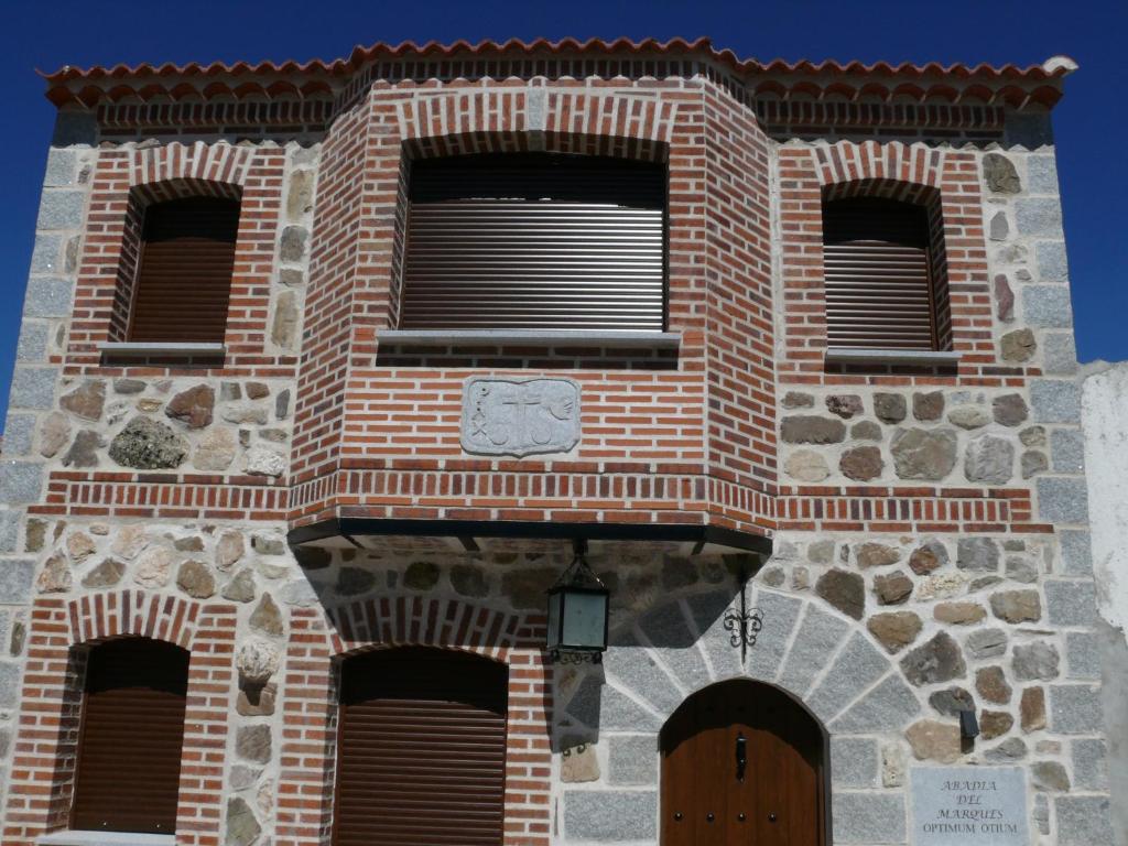 um edifício de tijolos com janelas e um relógio em Abadía del Marqués de Avila em Vega de Santa María