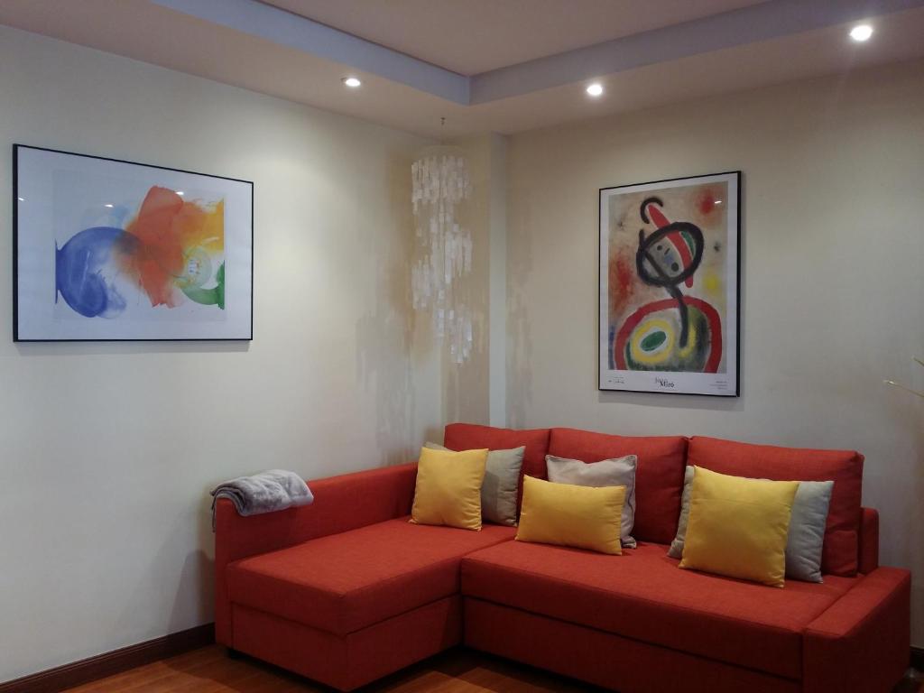 a red couch with yellow pillows in a room at Casa Cafer in Las Palmas de Gran Canaria