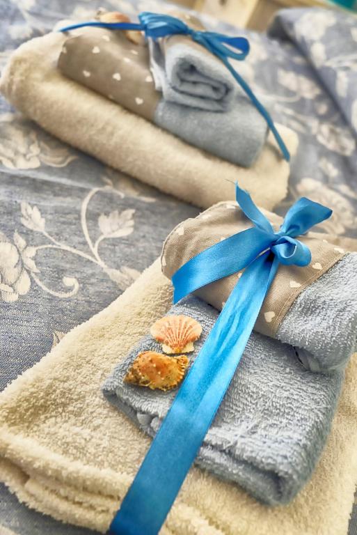 un nastro blu sopra asciugamani con conchiglia di B&B L'Arca Di Noè a La Spezia
