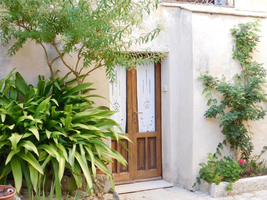 une porte en bois sur le côté d'un bâtiment orné de plantes dans l'établissement Appartamenti Liberty, à Erice