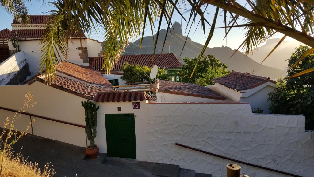 a white house with a green door and palm trees at Casa Santana Segura in Tejeda