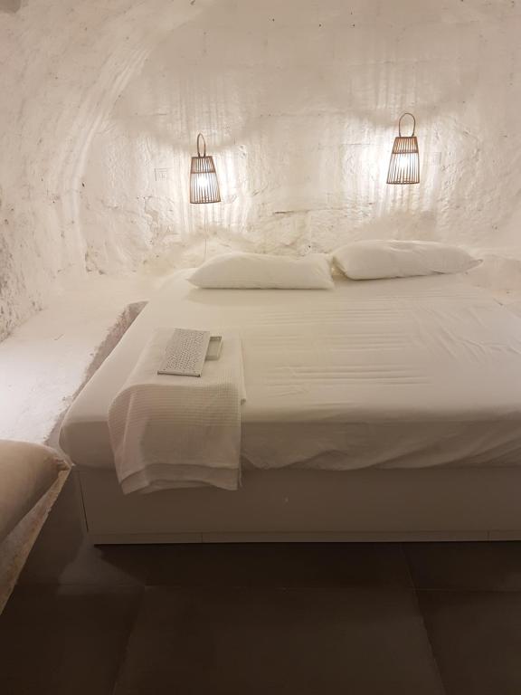オストゥーニにあるCasa Gorgoleの白いベッド(ライト2つ、本付)