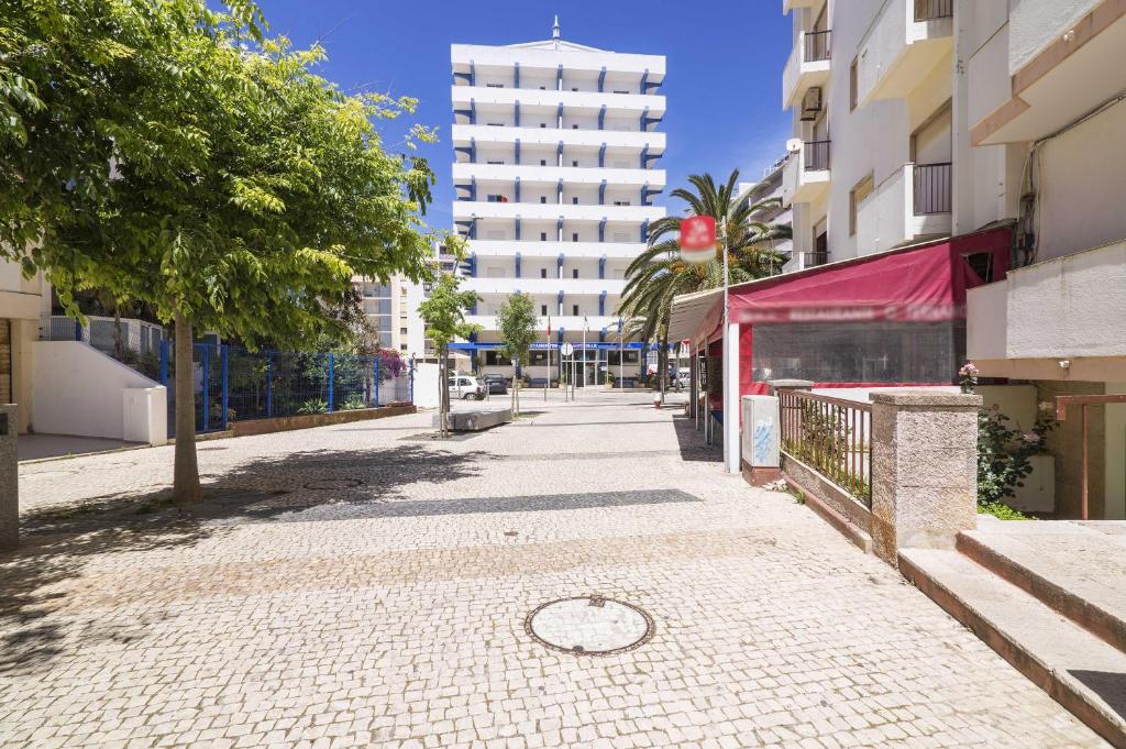 une rue vide dans une ville avec de grands bâtiments dans l'établissement Rosamar Apartamentos, à Armação de Pêra