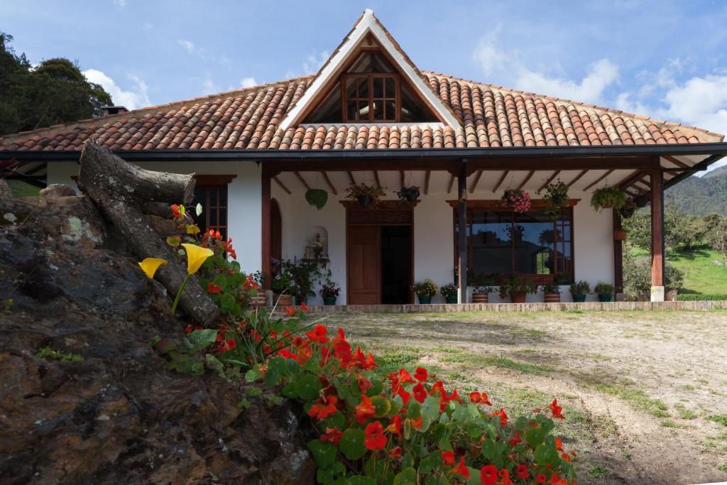 una casa con flores delante en Villa del Moján, en La Calera