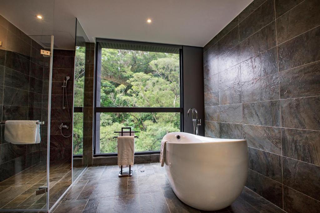 a bathroom with a tub and a large window at Platinum Hotel in Xindian