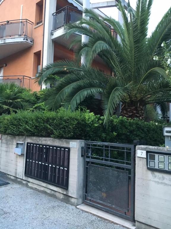 un cancello di fronte a un edificio con una palma di Residence IL PORTO a Fano