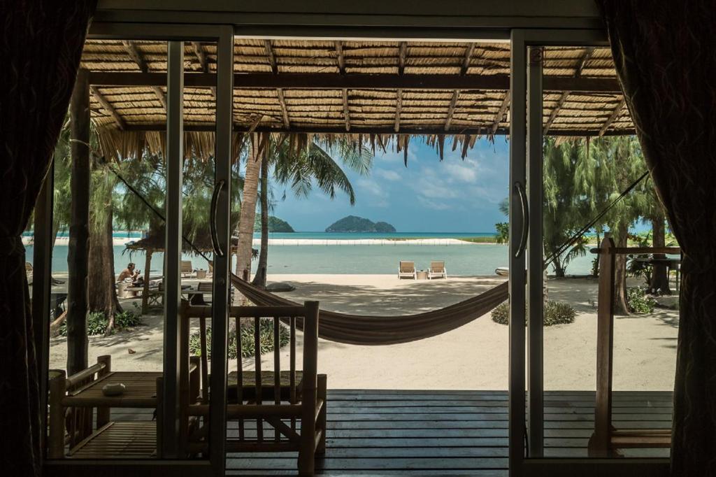 a view of the beach from the porch of a resort at Angkana Bungalows adults only in Thong Sala