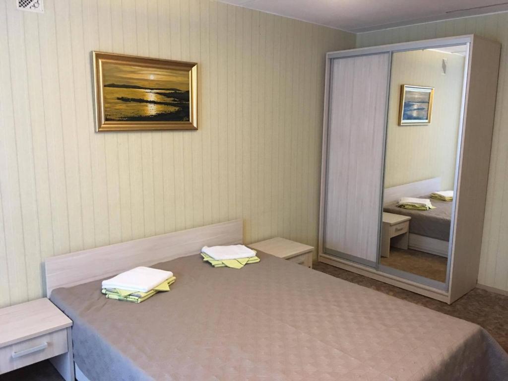 1 dormitorio con cama y espejo grande en KTU Rest House Politechnika, en Palanga