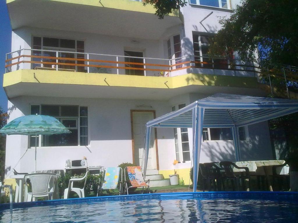 ein Haus mit Pool und Sonnenschirm in der Unterkunft Prima Guest House 2 in Sweti Konstantin