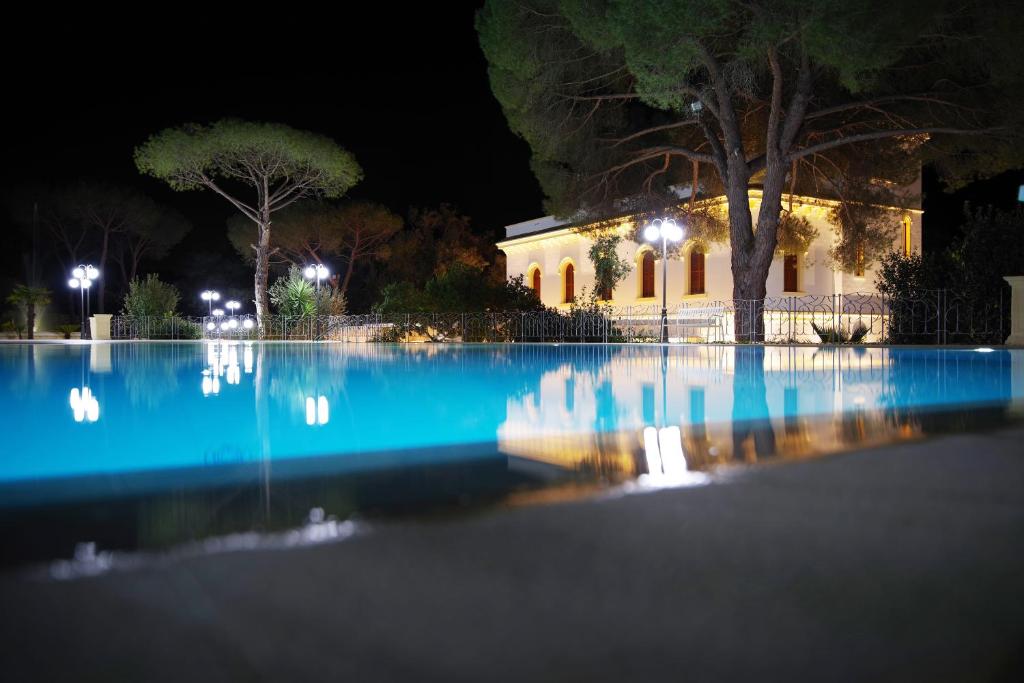 a swimming pool at night with a house in the background at Le scuderie di Villa Ravenna Luxury House in Sannicola