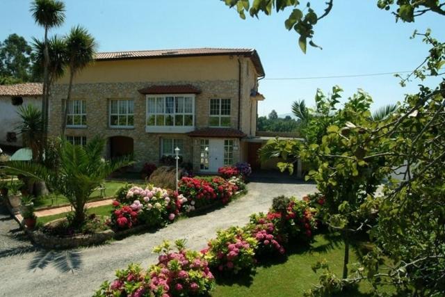 une maison avec un bouquet de fleurs devant elle dans l'établissement Pensión Toranda, à Niembro