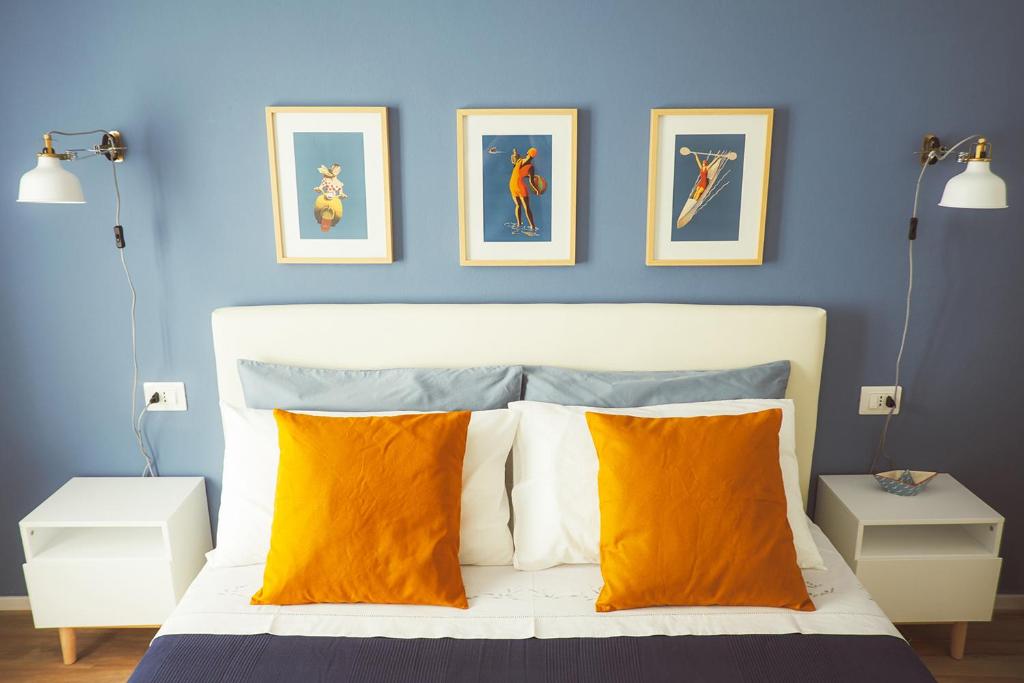 ラ・スペツィアにあるCasa Anne Marieの青いベッドルーム(オレンジ色の枕が付くベッド付)