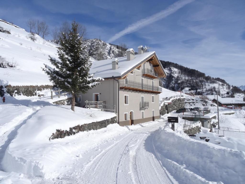 una casa en una colina nevada con una carretera cubierta de nieve en Pays du Grand St Bernard, en Saint-Rhémy