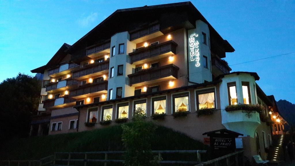 un gran edificio con un cartel en el costado en Hotel Al Prato en Fiera di Primiero