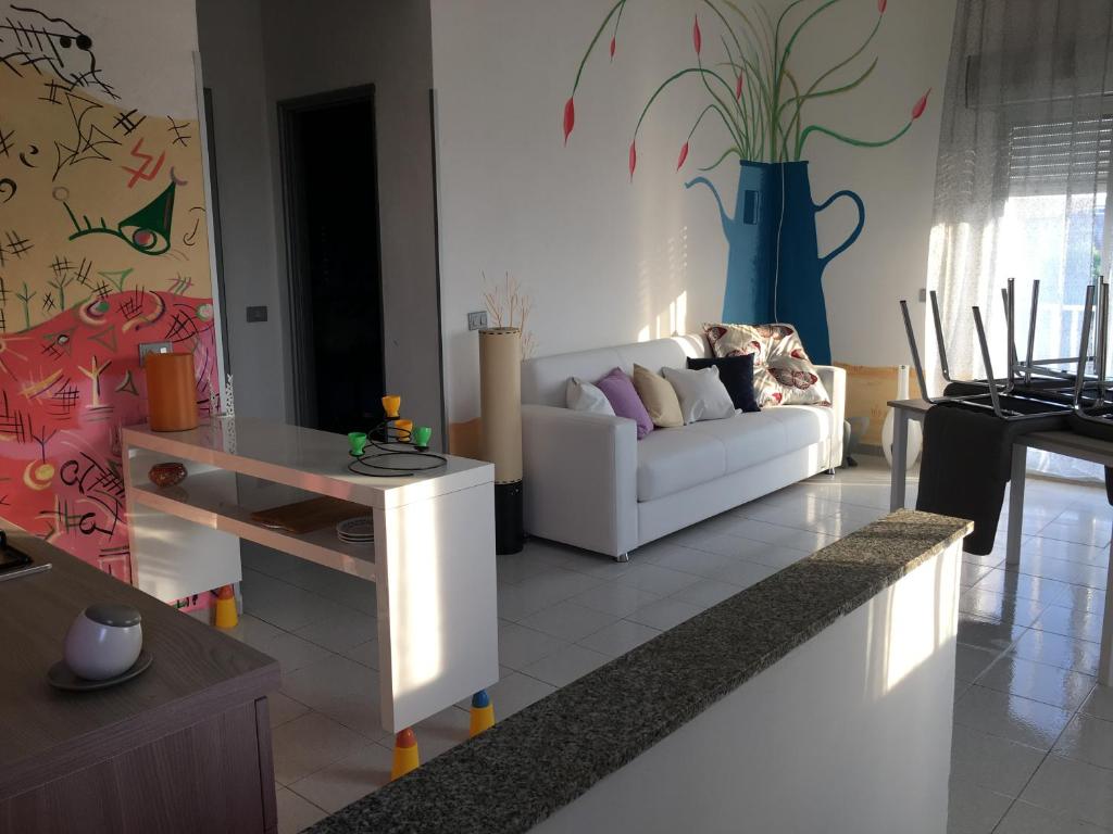 a living room with a white couch and a table at Casa anticaglie P.Secca in Punta Secca