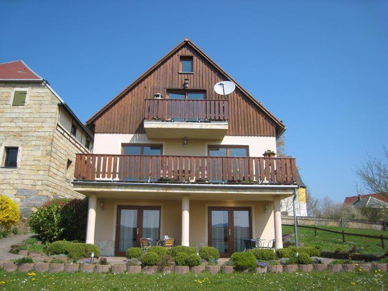 a large house with a balcony on top of it at Ferienwohnung-BergIdylle-bei-Hotel-BERGHOF in Lichtenhain