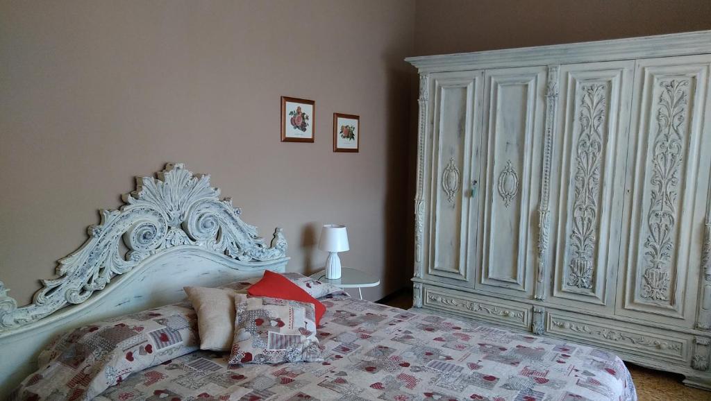 a bedroom with a white bed and a large white cabinet at Casa di Osio in Siena