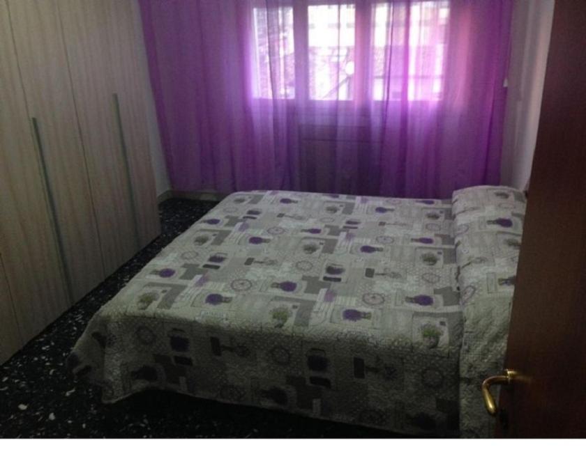 ラヴェンナにあるB&B AL CANDIANOのベッドルーム(紫色のカーテン付きのベッド1台付)