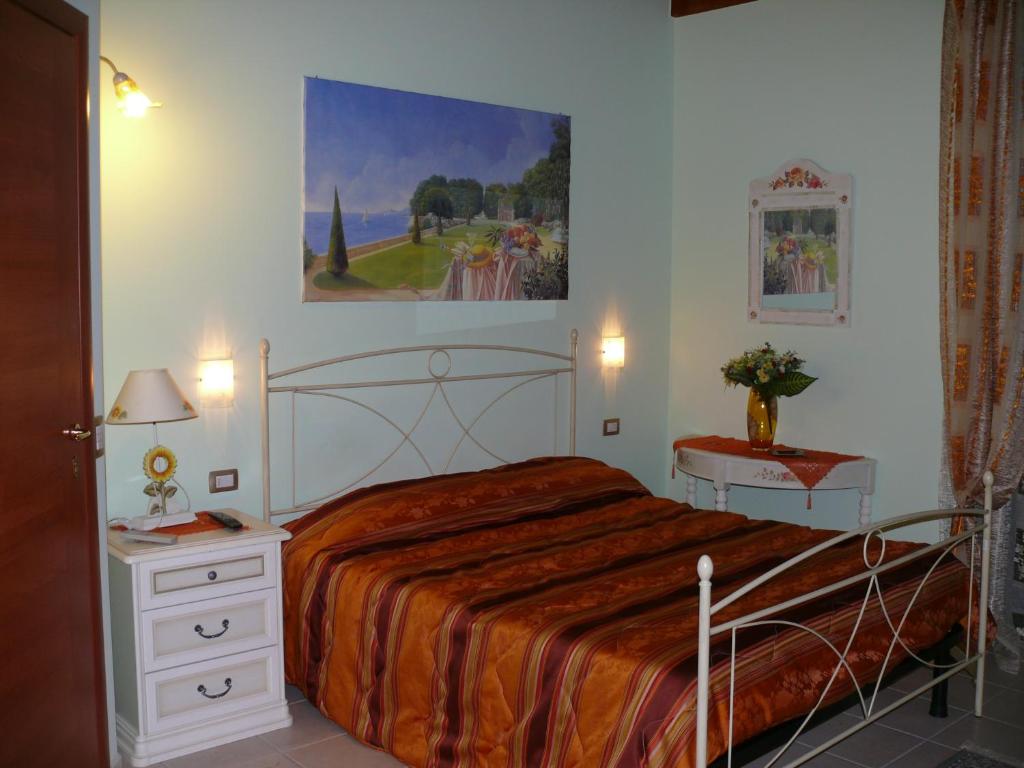 1 dormitorio con 1 cama y una pintura en la pared en B&B La Vecchia Stazione, en Gioiosa Ionica