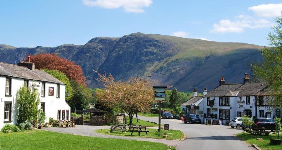 Strands Hotel/Screes Inn & Micro Brewery في Nether Wasdale: قرية صغيرة فيها جبل في الخلفية