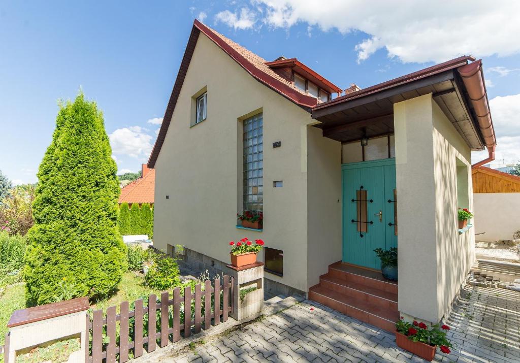 dom z niebieskimi drzwiami i płotem w obiekcie Villa Cihelna apartments w Czeskim Krumlovie