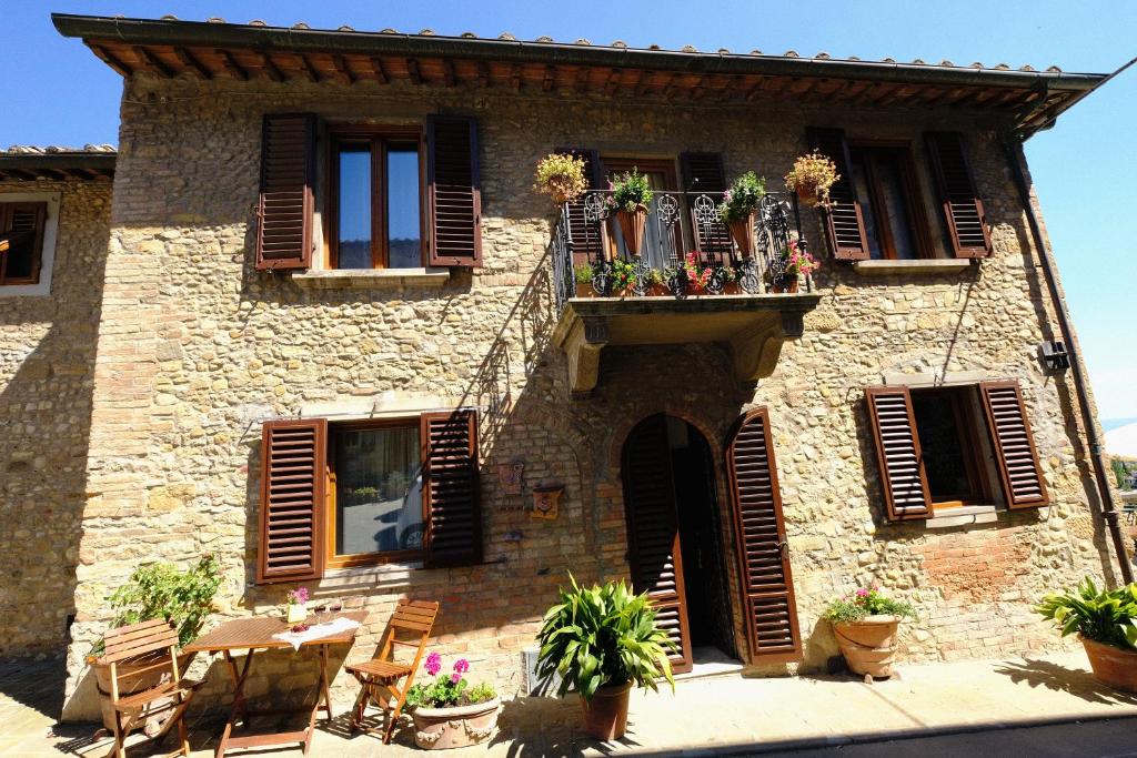 um antigo edifício de pedra com uma varanda e janelas em Il Torrino em Barberino di Val dʼElsa