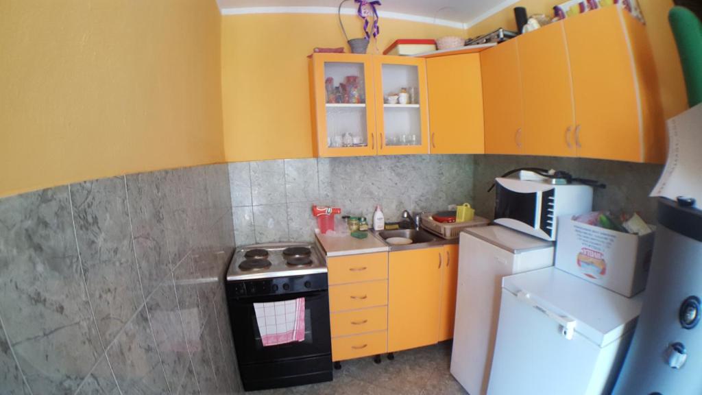 a small kitchen with a stove and a refrigerator at Guesthouse Stankovic in Sutomore
