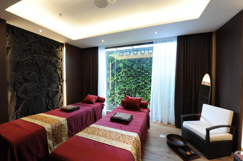 a room with two beds and a chair and a window at Hotel Borobudur Jakarta in Jakarta