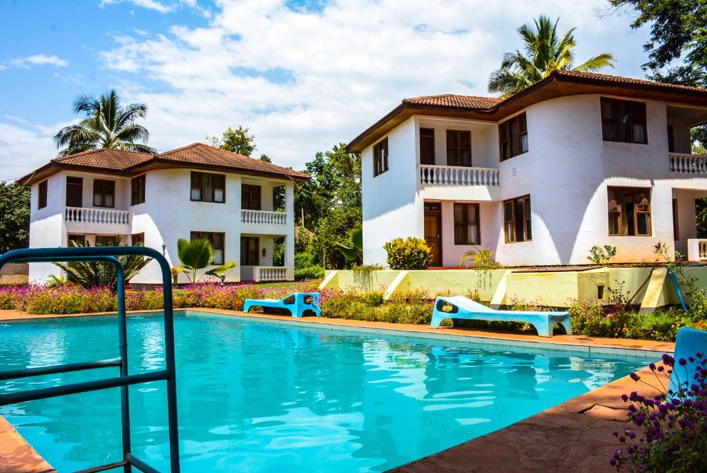 a swimming pool in front of a house at Keys Hotel Mbokomu Branch in Moshi