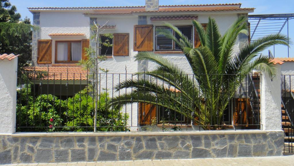 een huis met een palmboom voor een hek bij Apartmento Sant Pau 7 in Llança